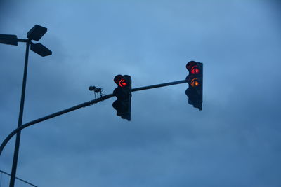 Low angle view of road signal against sky