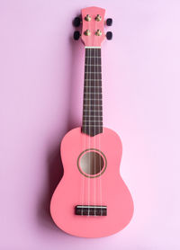 Close-up of guitar against pink background