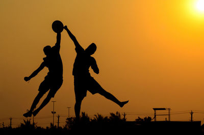 Silhouette men against sky during sunset