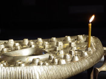 Close-up of illuminated candles on table