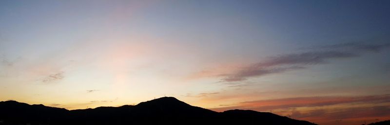Low angle view of silhouette mountains against dramatic sky