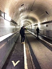 Rear view of people walking in subway station