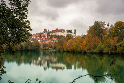 Scenic view of lake by buildings against sky