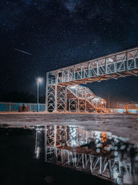 Reflective image of a crossover in railway station with the sky full of stars