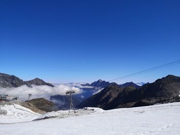 Scenic view of snowcapped mountains against clear blue sky