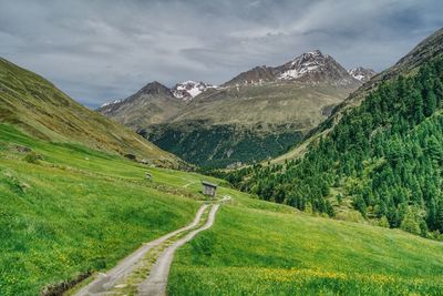 Scenic view of road amidst mountains against sky