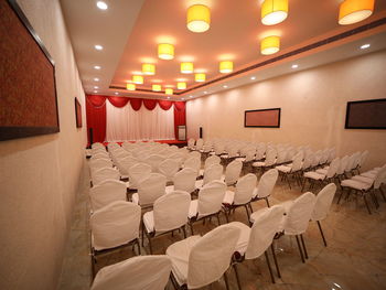 Empty chairs and tables in illuminated room