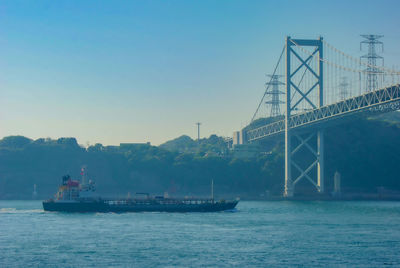 Boats in sea against clear sky