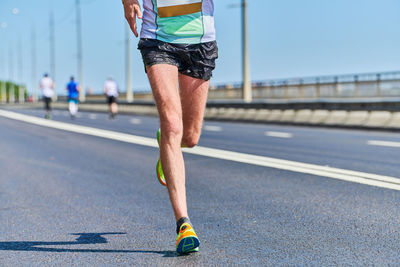 Low section of man running on road