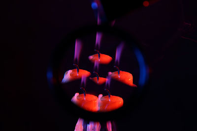 Close-up of lit candle in the dark