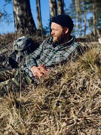 Man looking away from the camera while sitting on land