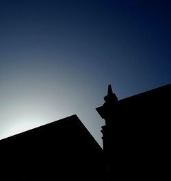 Low angle view of silhouette building against clear sky