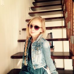 Mid adult woman wearing sunglasses standing at home