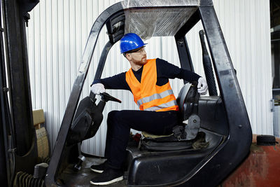 Worker on forklift in factory turning round