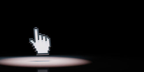 Close-up of light bulb on table against black background