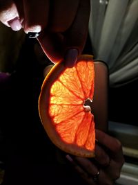 Midsection of person holding orange slice