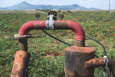 Close-up of rusty machine part on field