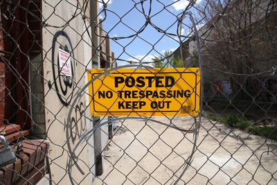 Warning sign on chainlink fence