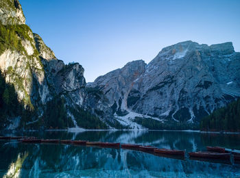 Scenic view of lake and mountains against clear blue sky