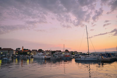 Boats in harbor at sunset