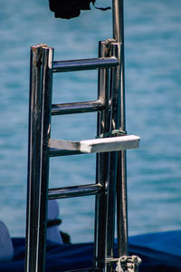 Close-up of metal railing against sea