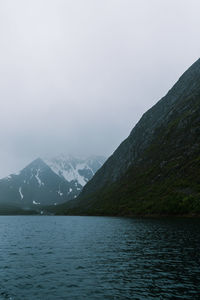 Scenic view of lake by mountains against sky