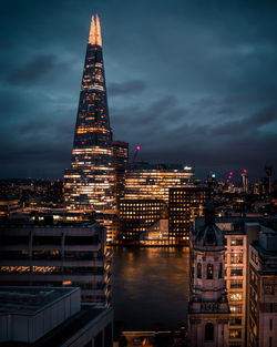 Illuminated cityscape against sky at night