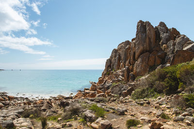 Rock formation on beach against sky