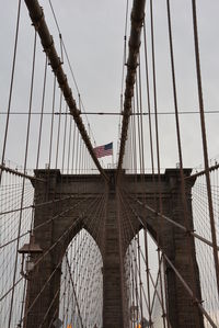 Low angle view of suspension bridge against sky