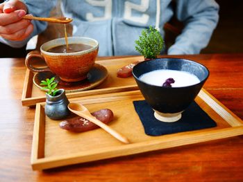 Close-up of woman holding tea cup on table