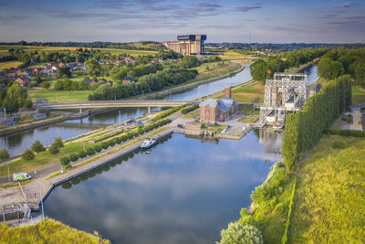 Panoramic view of bridge over river by buildings against sky