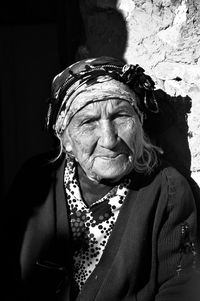 Portrait of senior woman against wall