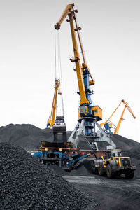 Cranes at construction site against clear sky