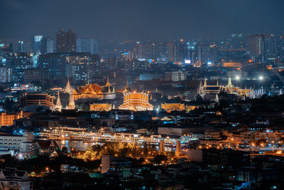 High angle view of illuminated buildings against sky at night