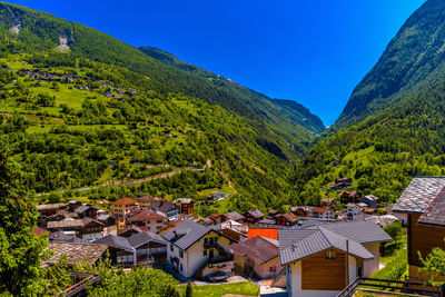 High angle view of townscape by mountains against blue sky