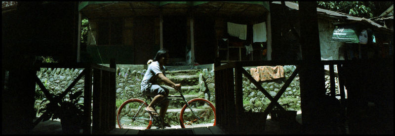 Rear view of man riding bicycle on building