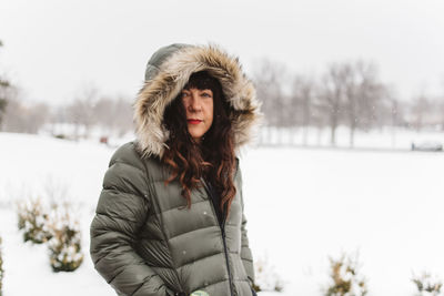 Portrait of young woman standing in snow