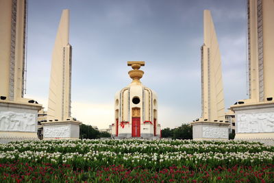 Flowers at democracy monument against sky