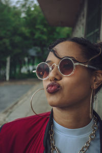 Portrait of woman wearing sunglasses blowing kisses