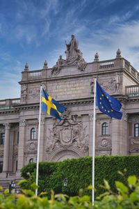 Sveriges riksdag med svensk samt europeiska unionens flagga