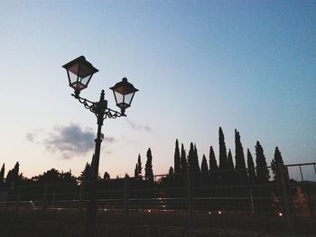 Low angle view of silhouette street lights against clear sky