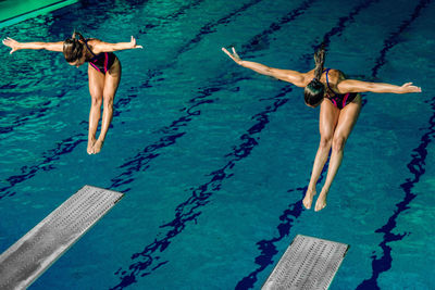 High angle view of athletes diving into swimming pool