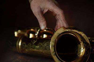 The hands of a musician on the saxophon - an ancient musical wooden instrument popular in jazz music