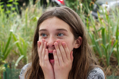 Close-up of surprised young woman looking away