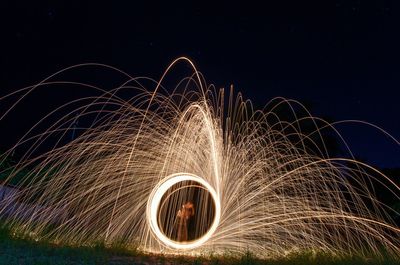 Man spinning wire wool on field against clear sky