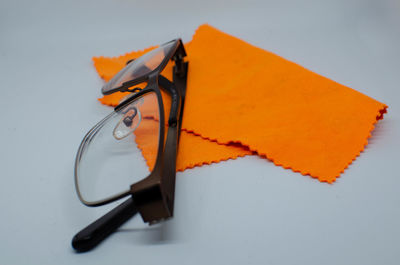 High angle view of eyeglasses on paper against white background