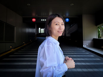 Portrait of young woman standing at home