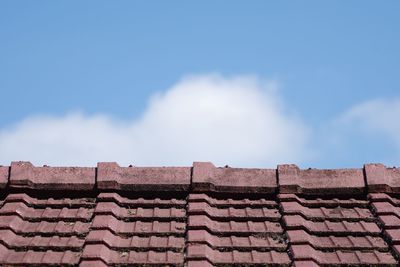 Low angle view of roof tiles against sky