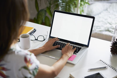 Young woman working at desk with laptop