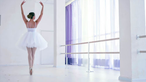 Rear view of ballerina dancing in studio